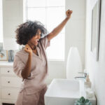 Happy relaxed millennial African girl in pajama enjoying her morning.